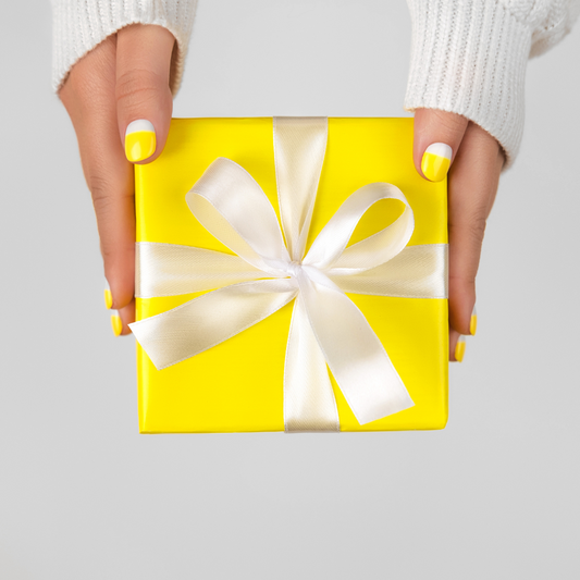 woman holding a yellow gift box with ribbon