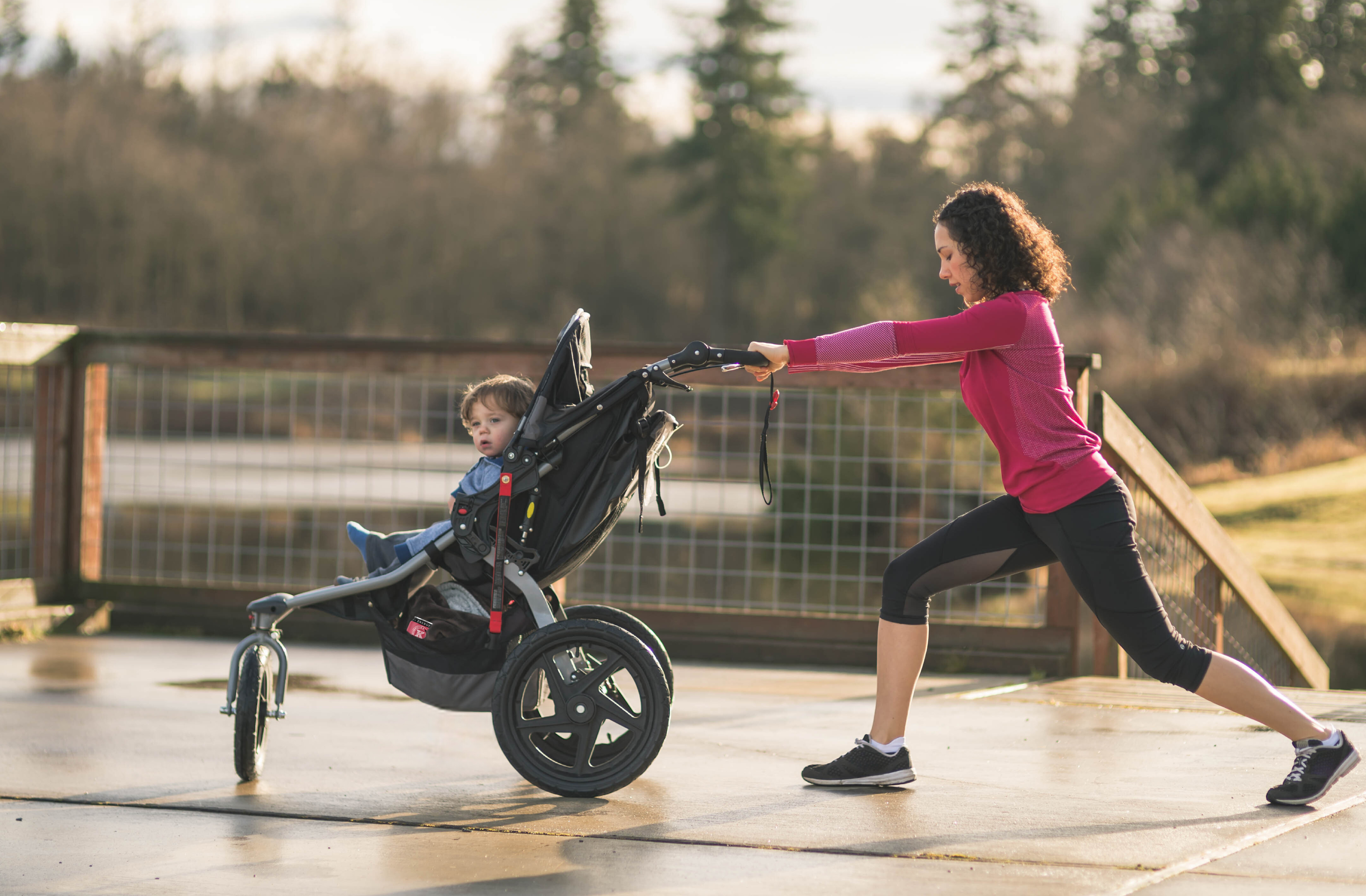 mother pushing toddler son in a stroller