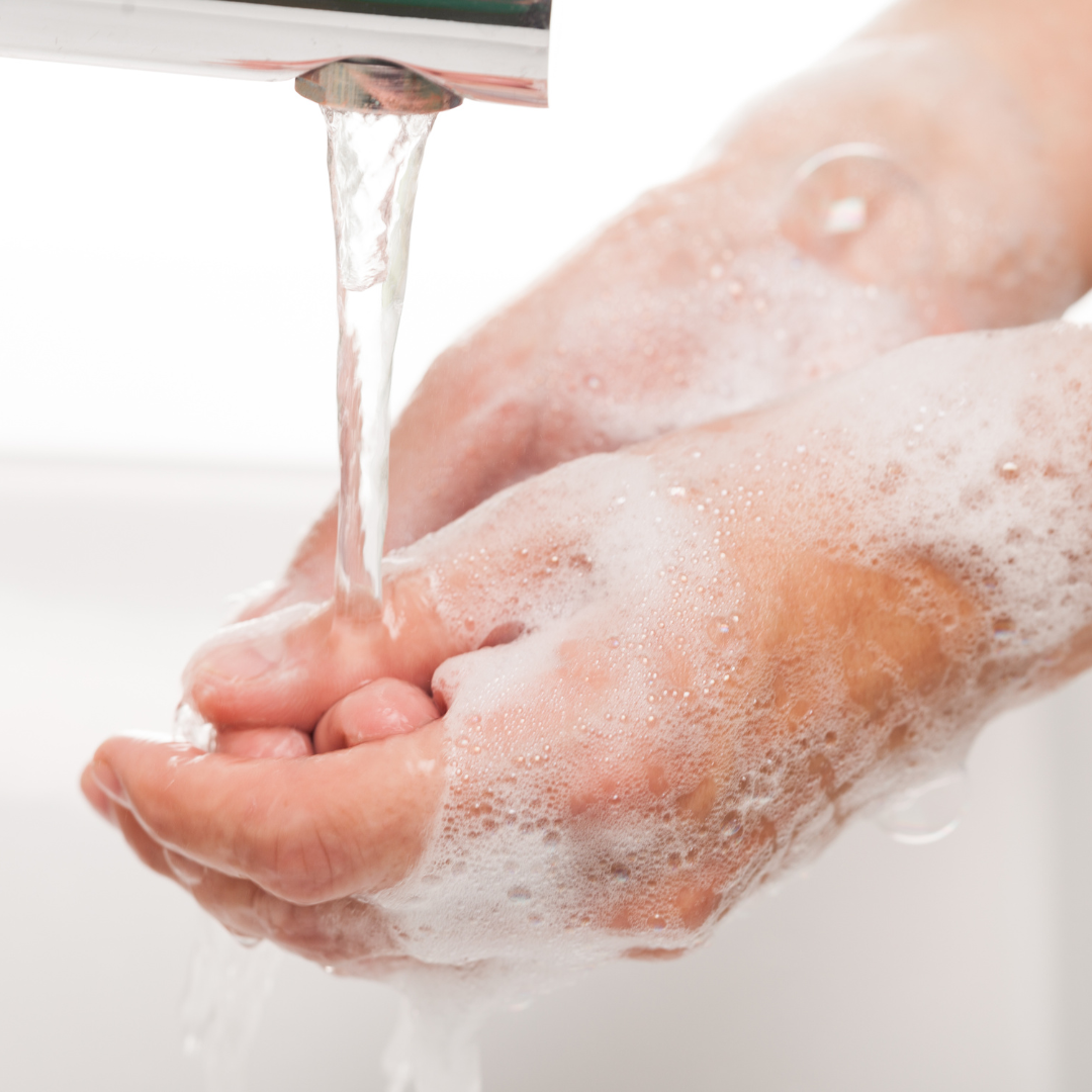 washing hands in a faucet with soap and bubbles